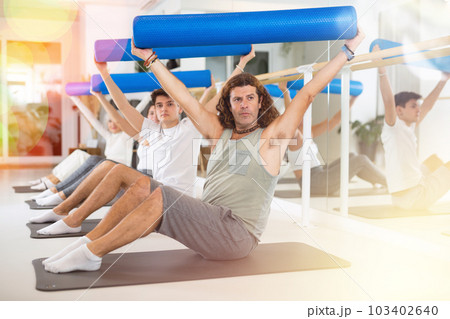 Adult man doing pilates with roller 103402640
