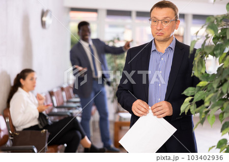 Angry hot-tempered boss shouts yells at hired employee man in office reception. 103402936