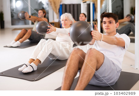 Young boy doing pilates with ball 103402989