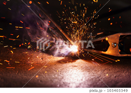 welder working with welding on metal with a sparking light welder working with welding on metal with a sparking light 103403349