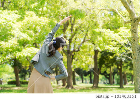 新緑の中で運動するスーツ姿の女性画像 103403351