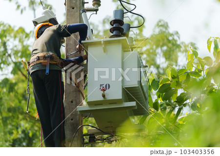 worker install a three-phase current transformer on electric pole 103403356
