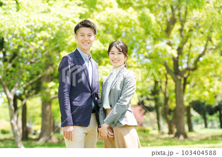 新緑の中に立つ男女ポートレート 103404588