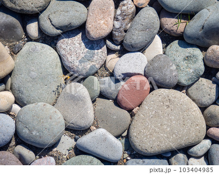 Background from multicolored pebbles. Black sand. Pebble coast. Stone beach. Stone pattern. 103404985