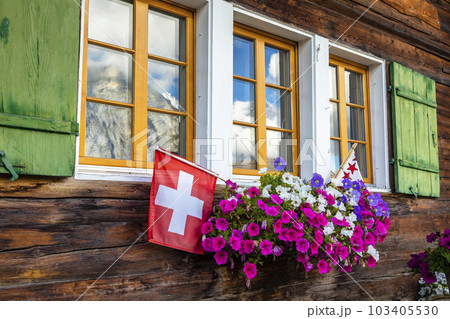 Flowers in rustic balcony at springtime with Swiss flag, Interlaken, Switzerland 103405530