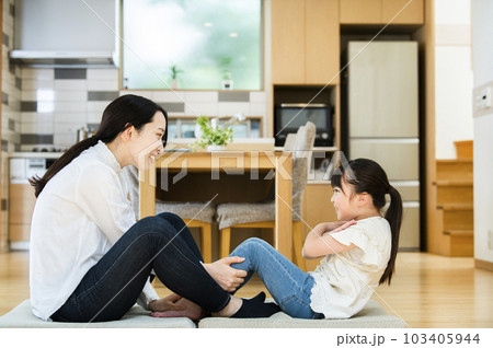 自宅のリビングで腹筋をする母と娘 103405944