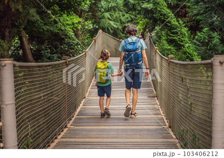 father and son tourists in Rope bridge in Yildiz Park. Besiktas, Istanbul, Turkey. Turkiye. Traveling with kids concept father and son tourists in Rope bridge in Yildiz Park. Besiktas, Istanbul, Turkey. Turkiye. Traveling with kids concept 103406212