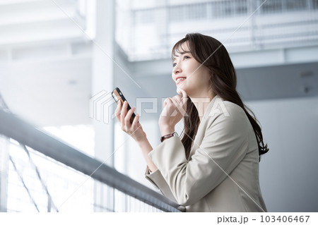 オフィスでスーツ姿でスマホ持つ転職などを迷ったり考える美人な女性 オフィスでスーツ姿でスマホ持つ転職などを迷ったり考える美人な女性 103406467
