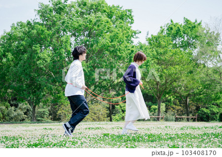 花畑で電車ごっこをするカップル 花畑で電車ごっこをするカップル 103408170