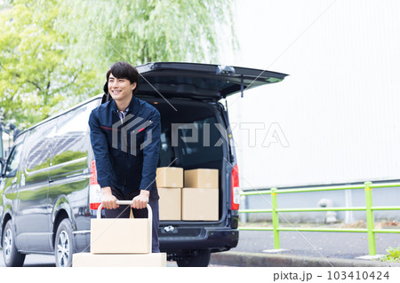物流　台車で荷物を運ぶ配達員 103410424