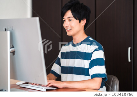 パソコンを使い課題を提出する若い男性 パソコンを使い課題を提出する若い男性 103410766