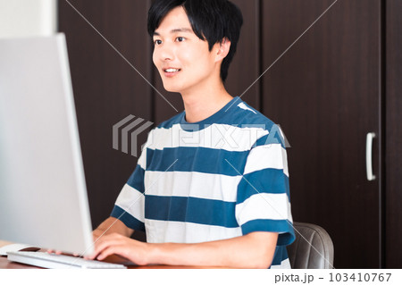 パソコンを使い課題を提出する若い男性 パソコンを使い課題を提出する若い男性 103410767