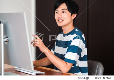 パソコンを使い課題を提出する若い男性 103410768