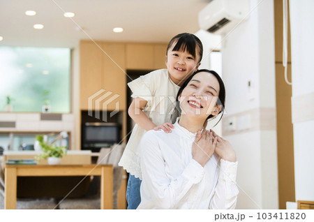 お母さんの肩を揉む女の子 103411820