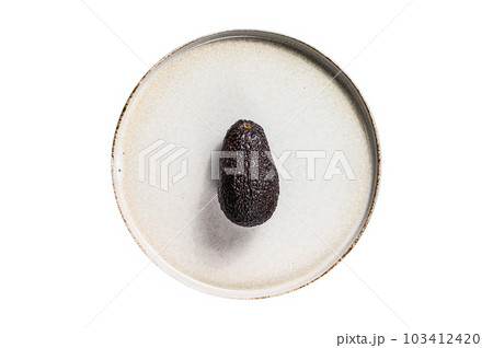 Avocado on a clay plate. Isolated on white background. 103412420