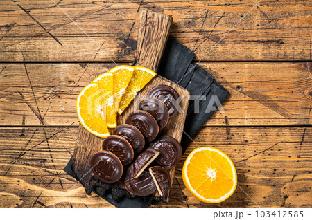 Chocolate Jaffa Cakes with Orange Flavored Marmalade. Wooden background. Top view Chocolate Jaffa Cakes with Orange Flavored Marmalade. Wooden background. Top view 103412585