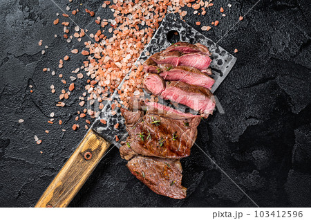 Sliced grilled Lamb fillet steak, mutton meat from leg. Black background. Top view Sliced grilled Lamb fillet steak, mutton meat from leg. Black background. Top view 103412596