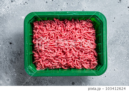 Raw Minced Meat in a Plastic Container, ground beef. Gray background. Top view 103412624