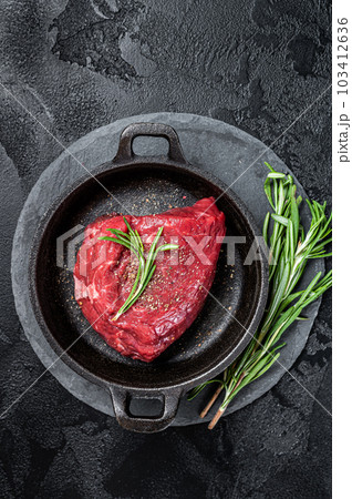 Fresh Raw sirloin rump steak in a skillet with herbs. Black background. Top view Fresh Raw sirloin rump steak in a skillet with herbs. Black background. Top view 103412636
