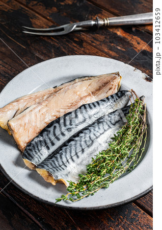 Salty sliced mackerel fillet fish in a plate with herbs. Wooden background. Top view Salty sliced mackerel fillet fish in a plate with herbs. Wooden background. Top view 103412659
