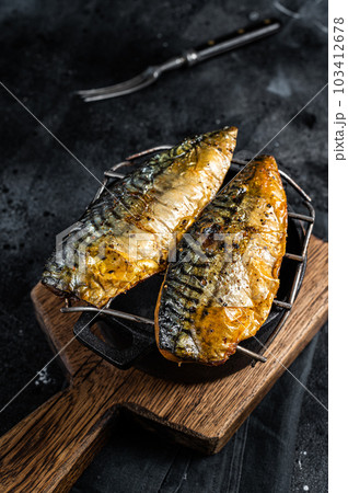 Grilled mackerel fish fillet on a grill. Black background. Top view 103412678