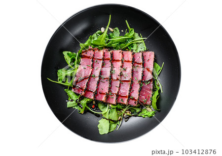 Grilled teriyaki Tuna steak salad with arugula and spinach. Isolated on white background. 103412876