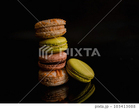 Reflection of Delight: Brown and Green Macaroons on Dark Mirror Background Reflection of Delight: Brown and Green Macaroons on Dark Mirror Background 103413088