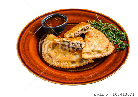 Fried empanadas with minced beef meat served on a plate with chili sauce. Isolated on white background. Fried empanadas with minced beef meat served on a plate with chili sauce. Isolated on white background. 103413671