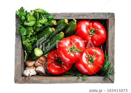Fresh vegetables in a wooden box, red tomatoes, green cucumbers with herbs. Isolated on white background. Fresh vegetables in a wooden box, red tomatoes, green cucumbers with herbs. Isolated on white background. 103413873
