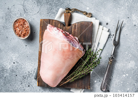 Uncooked Raw pork ham hocks, shanks on a wooden board with spices. Gray background. Top view 103414157