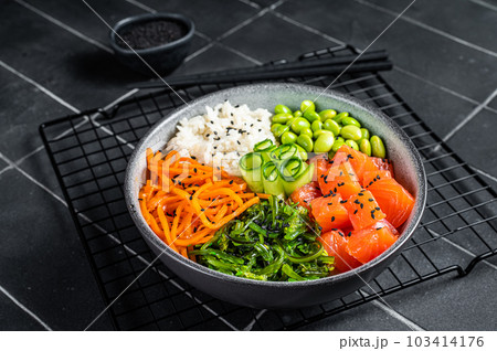 Hawaiian Poke bowl with Salmon, Edamame and Rice. Black background. Top view 103414176