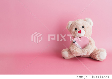 クマのぬいぐるみと注射器 ピンク背景の医療イメージ クマのぬいぐるみと注射器 ピンク背景の医療イメージ 103414224
