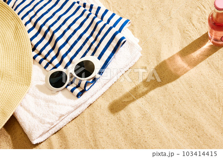 Shadow of beer glass and bottle on warm sand with beach stuffs. Chilling on warm summer day with cool drink Shadow of beer glass and bottle on warm sand with beach stuffs. Chilling on warm summer day with cool drink 103414415