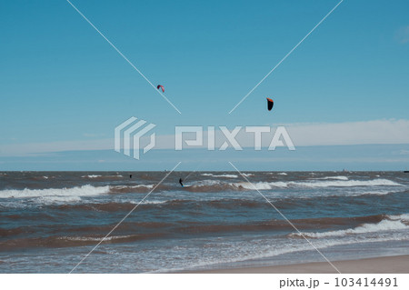 Wing Foiling kitesurfing wind surfing water outdoor sport in Baltic sea Dark blue clouds ocean water surface with foam waves before storm, dramatic seascape 103414491