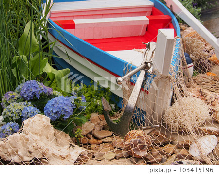 Installation on a marine theme, boat, anchor, nets. Details of the garden interior, marine-style decoration. 103415196