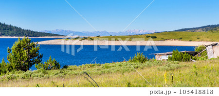 Beautiful lake and mountains view with old wooden house Beautiful lake and mountains view with old wooden house 103418818