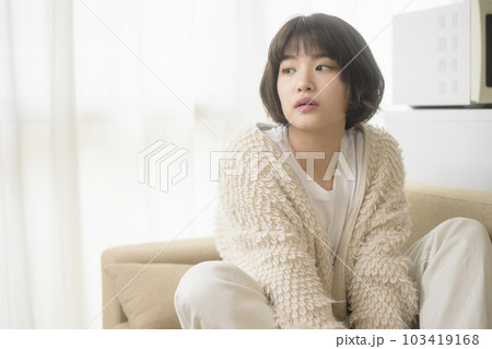 ソファでくつろぐ若い女性（ブラックミストフィルター） 103419168