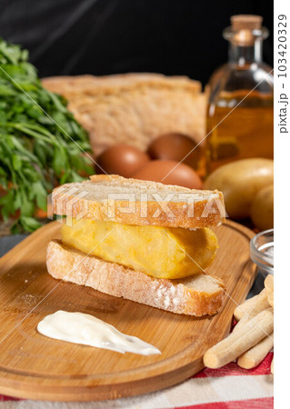 Spanish omelette with potatoes and onion, typical Spanish cuisine. Tortilla espanola. Rustic dark background Spanish omelette with potatoes and onion, typical Spanish cuisine. Tortilla espanola. Rustic dark background 103420329