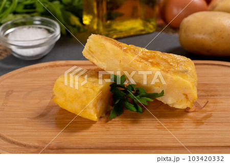 Spanish omelette with potatoes and onion, typical Spanish cuisine. Tortilla espanola. Rustic dark background Spanish omelette with potatoes and onion, typical Spanish cuisine. Tortilla espanola. Rustic dark background 103420332