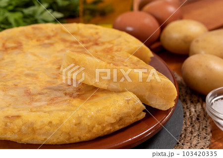 Spanish omelette with potatoes and onion, typical Spanish cuisine. Tortilla espanola. Rustic dark background Spanish omelette with potatoes and onion, typical Spanish cuisine. Tortilla espanola. Rustic dark background 103420335
