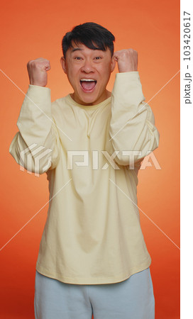 Asian chinese happy man celebrating success, winning, birthday, lottery jackpot goal achievemen Asian chinese happy man celebrating success, winning, birthday, lottery jackpot goal achievemen 103420617