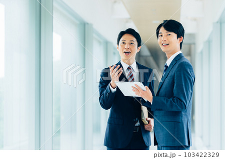 タブレットを持って話すビジネスマン 103422329