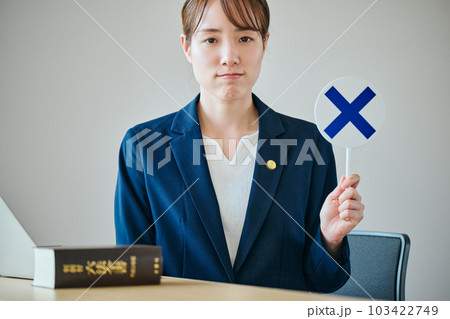 ばつの判定をする若い女性弁護士 103422749