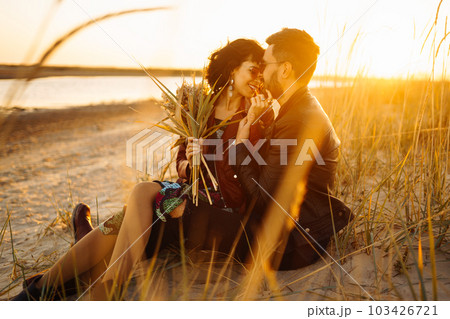 Enjoying time together. Stylish and loving couple enjoying each other by the sea. 103426721