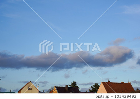 Picturesque view of the roofs of private houses and blue sky with a cloud Picturesque view of the roofs of private houses and blue sky with a cloud 103429492