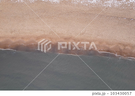 Winter in cold Baltic sea snowy beach in Gdansk. Aerial view of snow covered beach and dunes and dark calm sea nature landscape captured with drone. Tourism in Poland Winter in cold Baltic sea snowy beach in Gdansk. Aerial view of snow covered beach and dunes and dark calm sea nature landscape captured with drone. Tourism in Poland 103430057