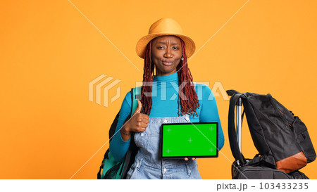 Smiling adult with greenscreen on tablet, showing isolated display on digital device. Young tourist being cheerful holding blank mockup chroma key template, weekend activities. Smiling adult with greenscreen on tablet, showing isolated display on digital device. Young tourist being cheerful holding blank mockup chroma key template, weekend activities. 103433235