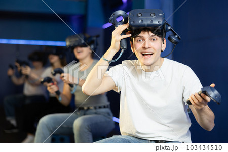 guy is exhilarated by turn of events in VR game and moved virtual reality glasses to forehead 103434510