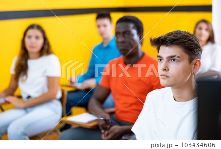 Group of adult students learn the rules of working in a taxi while sitting in driving school class 103434606