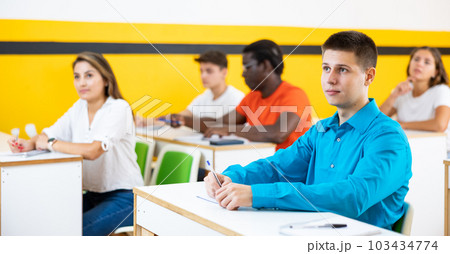 Young man attending lecture in taxi training school 103434774